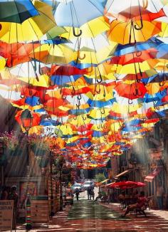 Umbrellas Street, Portugal. From July to September hundreds of colorful umbrellas float above the shopping promenades of Agueda, Portugal as part of the local Agueda Art Festival.