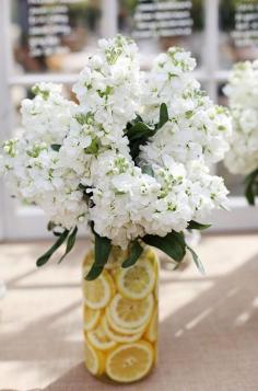 
                    
                        This unique floral arrangement has a floral vessel filled with lemon slices that makes the arrangement so fresh.
                    
                