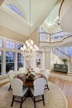 Gorgeous open dining area. Love the high ceilings contrast, light fixture and round table.