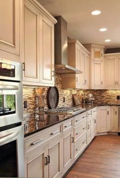 light cabinets, dark counter, oak floors, neutral tile black splash. Cabinet color