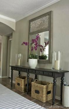 (Living Room Entryway) Pottery Barn Console with large hurricane candle holders, a huge gray mirror and baskets underneath - Love this look!