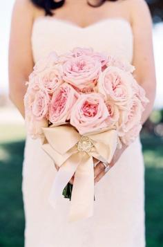
                    
                        A cream ribbon bow accented with pearl adds an elegant touch to this lush pink bridal bouquet.
                    
                