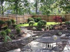 The retaining walls and plant beds are nicely done. The stone patio with the iron furniture is nice too.