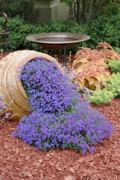 Outdoor Flower Planter Ideas | Tilted flower pot idea spilling purple flowers