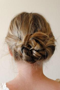 two braided pigtails towards the back and pinned in messy bun.
