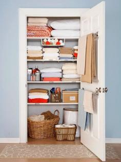 linen closet organization - great idea to put towel racks on the back of the door!