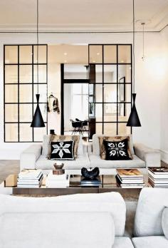Fantastic Scandinavian living room with matching pendant lamps and black and white accent pillows. Great industrial glass room dividers. #livingroom