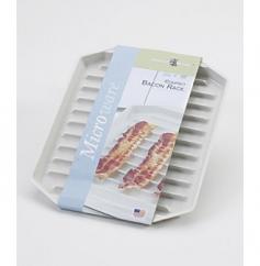 High-density plastic. Sloped design drains grease. Oven safe to 400&deg;F. Dishwasher safe. Dimensions: 8W x 10L inches. No more splattering pan grease to clean up the Nordic Ware Microwaveable Bacon Rack will perfectly cook your bacon and other small meats with no messy clean-up. The Microwaveable Bacon Rack is a bacon lover's dream. The ridges keep grease away from the slices of meat and the slanted design drains it away so your bacon will come out crispy and delicious every time. The durable plastic is microwave safe (fits great into smaller microwaves) and oven safe up to 400 degrees. When it's time to clean up simply place the rack into your dishwasher. With all the convenient features this rack will become a true time-saver. About Nordic Ware. Founded in 1946 Nordic Ware is a family-owned American manufacturer of kitchenware products. From its home office in Minneapolis Minn. Nordic Ware markets an extensive line of quality cookware bakeware microwave and barbecue products. An innovative manufacturer and marketer Nordic Ware is best known for its Bundt Pan. Today there are nearly 60 million Bundt pans in kitchens across America. The Nordic Ware name is associated with the quality dependability and value recognized by millions of homemakers. The company's extensive finishing technology and history of quality innovation and consistency in this highly technical and specialized area make it a true leader in the industrial coatings industry. Since founding Nordic Ware in 1946 the company has prided itself on providing long-lasting quality products that will be handed down through generations. Its business is firmly rooted in the trust dedication and talent of its employees a commitment to using quality materials and construction a desire to provide excellence in service to customers and never-ending research of consumer needs.