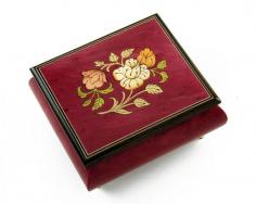 Leave a lasting impression with this incredible hand-made floral music jewelry box. Stained in a brilliant red wine stain, this gorgeous keepsake enables the right amount of the natural wood grain to come out. You can truly appreciate the quality that went in to constructing this wonderful work of art. This piece is entirely hand-made in Sorrento, Italy and is constructed using only the finest materials available. The extraordinary exterior features is complimented by its plush interior. Listen as the wonders of sound fill the room with a melody only a traditional mechanical movement can produce. It will sure bring moments of tranquility time and time again. With over 380+ tunes available, you're sure to find that perfect melody. Please see "item options" for available tunes or visit our "listening station" for all song titles as well as sample clips. Thank you very much for your interest in our products! Your satisfaction is always guaranteed at the Attic! Dimensions: Length - 4.25" Width -3.75 Depth (Height) - 2