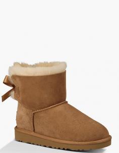 UGG AustraliaKids' Mini Bailey Bow Short Boot, Chestnut, 13T-4YDetailsSheepskin suede UGG boot with bow-ribbon on back Dyed shearling section (Australia), 100% UGGpure wool, or mixed shearling and UGGpure wool lining. Whipstitching over piping at upper. 3/4" lugged EVA rubber sole for traction. Wear barefoot to maximize benefits of plush moisture-wicking micro pile lining: keeps bare feet comfy in temperatures as low as -30 degrees Fahrenheit to as high as 80 degrees Fahrenheit. Imported. Sizing Note: Toddler sizes end in "T"; Youth sizes end in "Y". Toddler sizes are smaller than youth sizes. Designer About UGG Australia: When an Australian surfer visited the U.S. in 1978 and brought his home country's sheepskin boots with him, the idea for UGG Australia was born. With comfort and luxury as its two watchwords, UGG Australia soon built a stellar reputation in both categories. Beyond the well-known sheepskin boots spotted on a who's who-list of Hollywood stars, UGG Australia also features styles such as knit boots, shearling slippers, and leather hiking boots for men and women. Plus, there's a children's collection with wee sheepskin boots and even Mary Jane-style walking shoes.