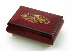 Leave a lasting impression in the hearts of those you love with this wonderful keepsake. This alluring red wine musical them music box is a remarkable show of the old world tradition of wood inlaying. The centerpiece of this incredible music box is the instrumental theme (violin, horn and sheet music) inlay design. This stunning array of colors sits against a stunning red wine stain with the burl-elm wood graining still visible. This musical keepsake demonstrates exemplarity craftsmanship in every detail. The hidden gem is located inside. Listen as the wonders of sound fill the room with a melody only a traditional mechanical movement can produce. It will sure bring moments of tranquility time and time again. With over 380+ tunes available, you're sure to find that perfect melody. Please see "item options" for available tunes or visit our "listening station" for all song titles as well as sample clips. Thank you very much for your interest in our products! Your satisfaction is always guaranteed at the Attic! Dimensions: Length - 6.5" Width - 4.5" Height - 2.75
