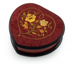 Definitely one of our more prestigious music boxes, this meticulously detailed, hand crafted work of art is an expression of eternal love. For it be art, music or life, we are proud to showcase this extravagant Italian musical jewelry box. The distinctive heart shape is truly expressive all in itself. The gorgeous wood inlay displays a traditional floral design incased in a fine heart shaped outline. This all sits against the exquisite red wine stain and natural wood graining of walnut and variants thereof. This music box is constructed of only materials available. A truly adorable an heartfelt sentiment, this music jewelry box will surely be appreciated for years to come. The extraordinary exterior features is complimented by its plush and roomy interior. Listen as the wonders of sound fill the room with a melody only a precision mechanical movement can produce. It will sure bring moments of tranquility time and time again. With over 380+ tunes available, you're sure to find that perfect melody. Please see "item options" for available tunes or visit our "listening station" for all song titles as well as sample clips. Thank you very much for your interest in our products! Your satisfaction is always guaranteed at the Attic! Dimensions: Length - 7.5" Width - 7.5" Height - 2.75