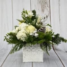 BRING WARMTH TO YOUR HOME THIS SEASON WITH THIS WHITE + SILVER TEXTURED POTTED ARRANGEMENT OF ASSORTED CHRISTMAS GREENS, FUJI MUMS AND CHEERFUL FROSTED PINECONES

