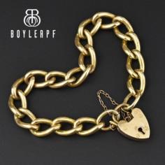 Beautifully secured and adorned with a large functioning padlock heart shape locking clasp, this antique Victorian curb chain link bracelet is rendered in a rich rolled gold plate. The curb chain also bears a safety chain as well as the heart clasp. No key necessary as the top of the lock opens. 