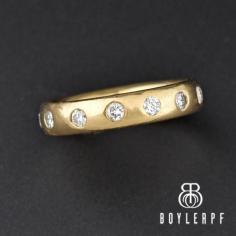 Beautiful vintage Art Deco-styled full eternity band ring featuring 13 bright-white diamonds adding up to 1 carat. The diamond gemstones are all open back and set in a thick 14K yellow gold wide band. Wear this wonderful ring as an anniversary ring, stack with others, or to accent an engagement ring.