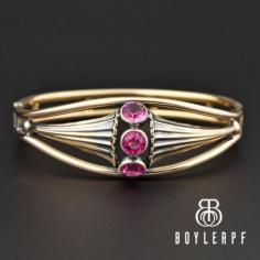 Superb Art Nouveau sterling silver gold vermeil bangle bracelet with simulated pink tourmaline in the front. The open back crystals are flanked on each side with an organic petal shape that graduates down to a double band having bars between. The hinged bracelet is closed on the side with a fold over clasp that attaches to a bar...quite a unique closing. Hallmarked on the back band Simmons, the bracelet is very feminine and a perfect example of late Victorian to Art Nouveau jewelry.