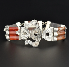  total of five colorful agate gemstones are capped with engraved sterling silver terminals in this Scottish 19th-century buckle bracelet. A large functioning engraved silver buckle closes the bracelet with the agates all varying in color from a rich deep brown, carnelian orange, and translucent beige. A rare, very hard to find antique Scottish bracelet with exceptional workmanship!