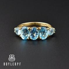 Beautiful and captivating quintet of royal blue topaz gemstones sparkle shoulder-to-shoulder across your finger in this 1960s half hoop band ring. The open back topaz are oval with pear shapes on the end and are set in a 10K yellow gold elevated mounting. Exceptional bauble for the December birthday, alternative engagement ring or doubling as a wedding or anniversary ring. A true classic.