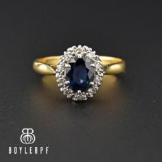 Beautifully framed by a halo of sparkling white diamonds, this breathtaking vintage ring centers on a deep blue oval sapphire, weighing roughly 1 carat. An emulation of classic early-twentieth-century Edwardian style, the ring is rendered in a fine 18K yellow gold and platinum. The sapphire is multi-prong set high with the diamonds in an open work base that allows light to shine through. The ring can double as an engagement ring, promise ring or just for saying 'I love you'! Very Princess Diana!