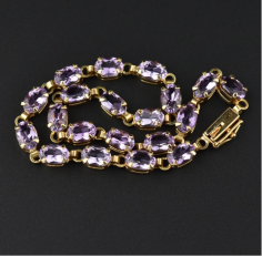 Elegant vintage 14K yellow gold bracelet with 10 carats of sparkling amethyst gemstones. Each purple gemstone is open back allowing for the ultimate light reflection. A slide clasp with accompanying pin safety catch complete the piece. Stunning to wear alone for just a little color or great stacked and layered with others!
