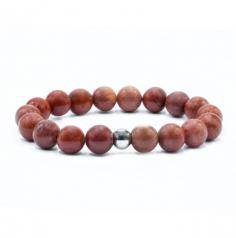 This Natural Stone bracelet showcases an opaque version of quartz, belonging to the Chalcedony mineral class. It has a vitreous luster and opaque transparency, creating a unique visual appeal. The bracelet comes in two styles, measuring 19 cm and 18 cm, and is designed to fit a wrist size of 18. The beads are rounded in shape and are available in two sizes: 8 mm and 10 mm. There are different bead counts to choose from, including 18, 19, 22, and one variant includes a Buddha charm. The bracelet is made with an elasticated rope for easy wearing.

The deep red coloring of this stone, ranging from bright red to brownish red, is truly captivating. This particular jasper has been revered as a stone of safeguarding for thousands of years. It holds the potential to generate and balance aggressive and high-powered energy, making it a valuable tool for maintaining energetic equilibrium.

Wearing this Natural Stone bracelet not only adds a stylish touch to your ensemble but also serves as a symbol of protection and energetic balance. Please note that gemstones have been associated with certain properties and beliefs, but their effectiveness may vary for individuals. They should not replace professional advice or treatment.