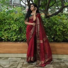 The Aishwarya Red Maheshwari Cotton Silk Saree is a vibrant red saree crafted in Maheshwari cotton silk, adorned with elegant golden floral motifs. It features a delicate pallu with narrow gold stripes and a beautiful diamond border in dull gold zari. The saree includes a running blouse, adding to its traditional charm. This piece offers a stunning look for festive occasions.
